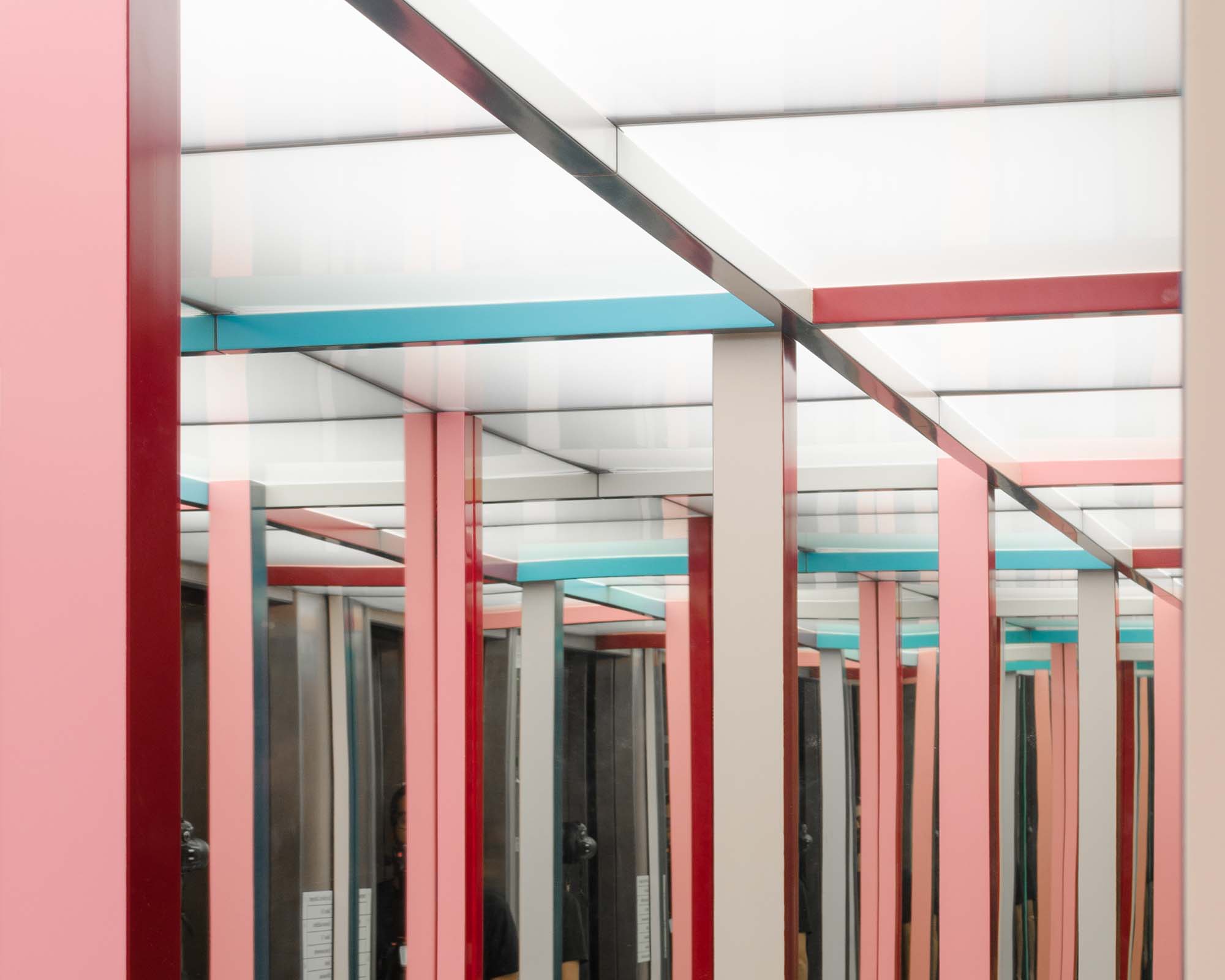 Instalação feita de perfis metálicos verticais coloridos no elevador da culturgest