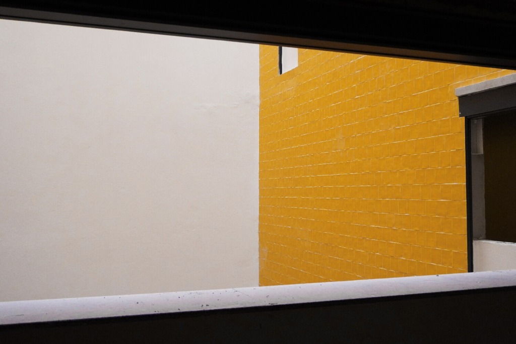 abertura rectangular sobre pátio interior com lateral de azulejo amarelo luminoso